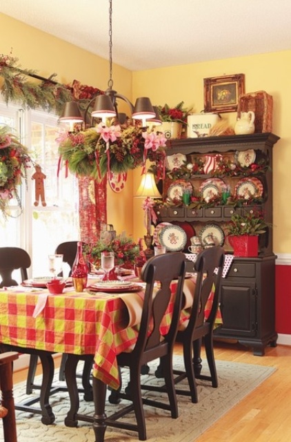 plaid, lots of red and yellow, printed porcelain, fabric blooms and an evergreen wreath for a Christmas feel in the space