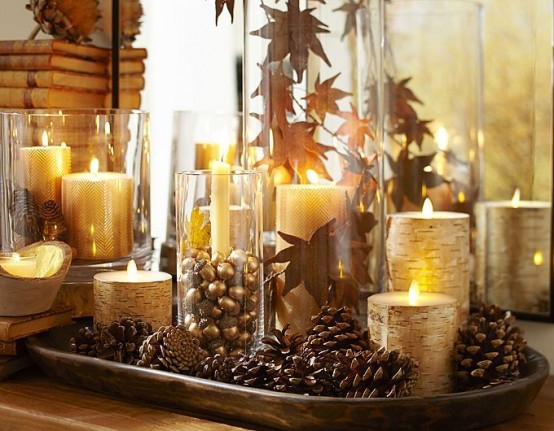 a simple and stylish centerpiece of a tray with pinecones, gilded candles, fall leaves and little acorns