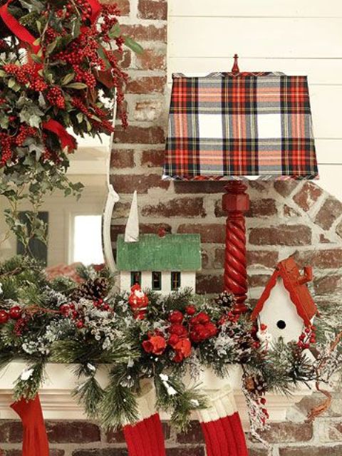 a red lamp with a plaid lampshade adds a cozy holiday feel to the space and makes it look festive