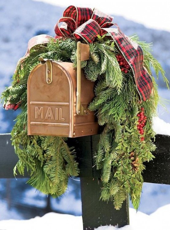 lovely mail box styling with evergreens, red berries and a red plaid bow on top is amazing and very festive-like