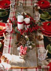 a plaid table runner, red berries, pinecones and pillar candles will dress up your table for Christmas with a cozy traditional feel