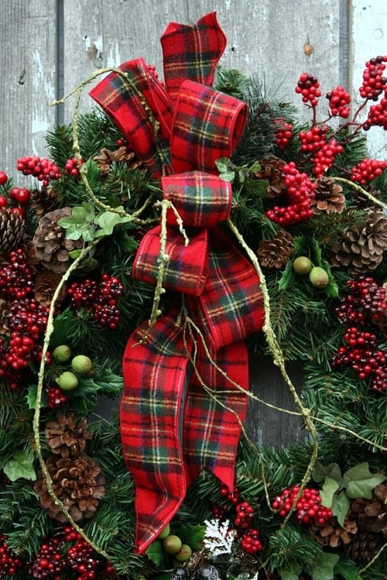 a lush evergreen Christmas with pinecones, berries, greenery and a large plaid bow that screams holidays at once