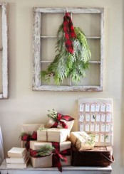 a whitewashed window frame with evergreens and a red plaid accent is a cool and easy decoration with a rustic feel