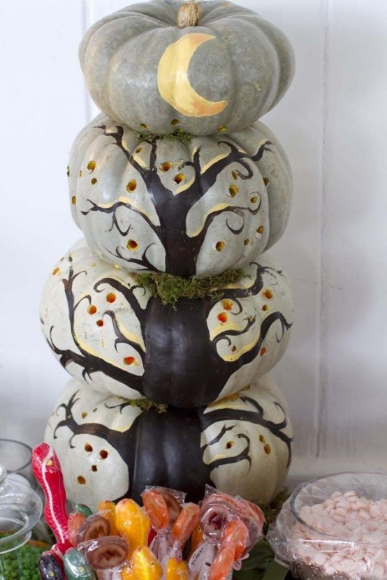 gorgeous rustic Halloween decor of heirloom pumpkins stacked and a tree and a moon painted on them