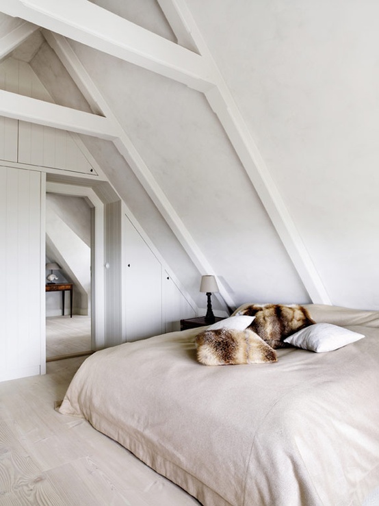 a small attic neutral Nordic bedroom with a neutral bed and a dark nightstand