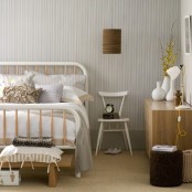 a Nordic bedroom with printed wallpaper, retro furniture, lamps, benches and a stool
