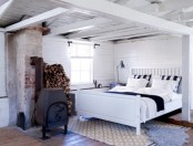 a vintage-inspired Nordic bedroom in white, with white planks, a metal hearth and a comfy bed plus rugs