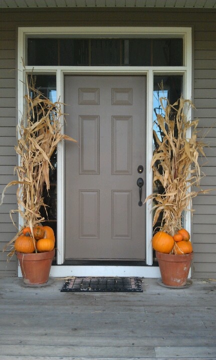 simple pot arrangements with orange pumpkins and corn husks will accent your front door and hint on Thanksgiving