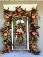 a super lush garland of burlap, plaid ribbons, greenery, fall leaves, faux pumpkins and flowers plus a matching wreath for a refined Thanksgiving front door