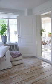 a Scandinavian space with wooden whitewashed shabby floors that give a nonchalat touch to the space