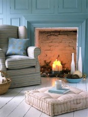 a cozy farmhouse living room in blue, with chic and comfy furniture, with a fireplace and a whitewashed floor to refresh the color scheme