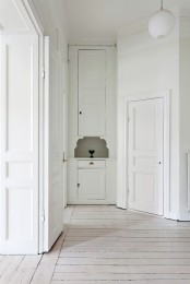 a refined white space with a whitewashed floor and softens the space a bit and gives it a warm touch