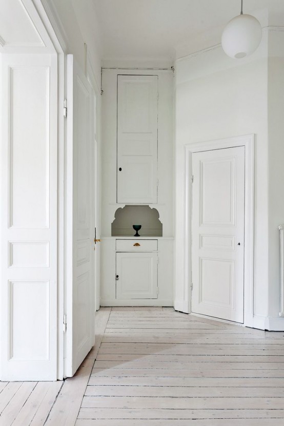 a refined white space with a whitewashed floor and softens the space a bit and gives it a warm touch