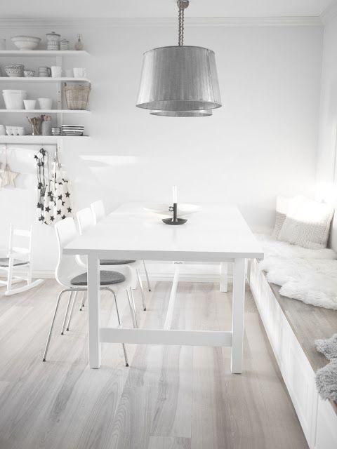 an all-white room with a whitewashed floor and metallic touches is airy, light-filled and very fresh