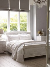 a white shabby chic bedroom with whitewashed floors and furniture is delicate and vintage-inspired
