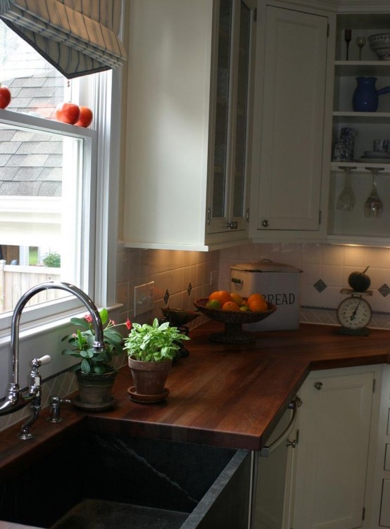a neutral farmhouse kitchen with rich stained butcherblock countertops that contrast it and make it bold and dramatic