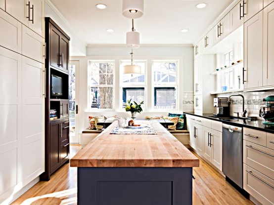 a modern neutral kitchen with a blue kitchen island and butcherblock countertops to contrast the space