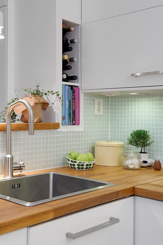 a contemporary neutral kitchen with light stained butcherblock countertops and an aqua tile backsplash is welcoming and airy