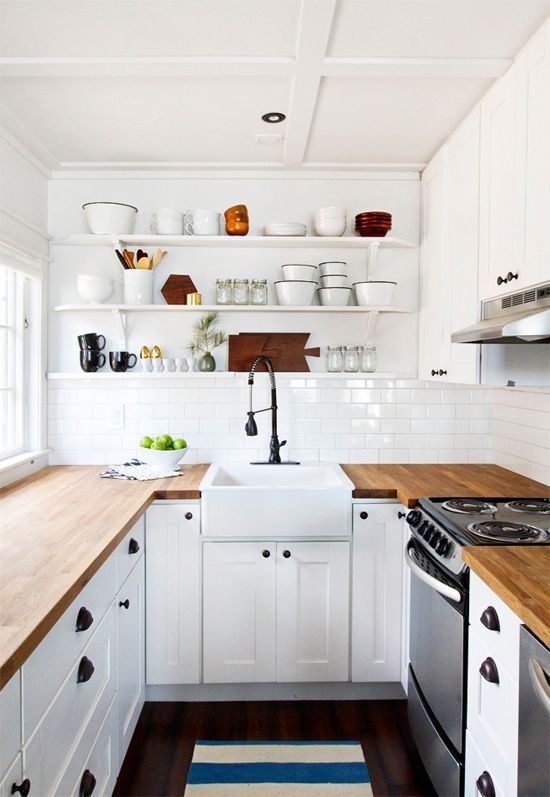 a modern white farmhouse kitchen with light stained butcherblock countertops that add warmth and interest to the space