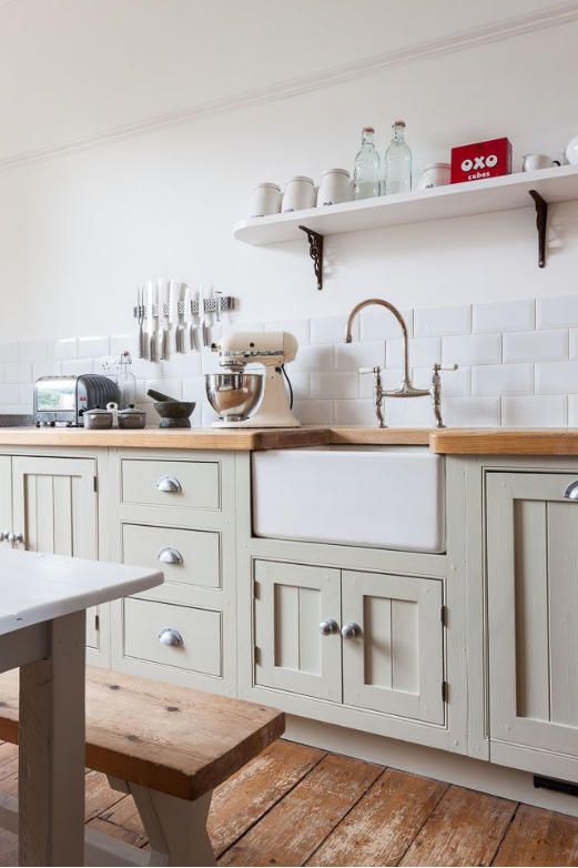 light stained wooden countertops paired beautifully with olive green cabinets create a stylish farmhouse look