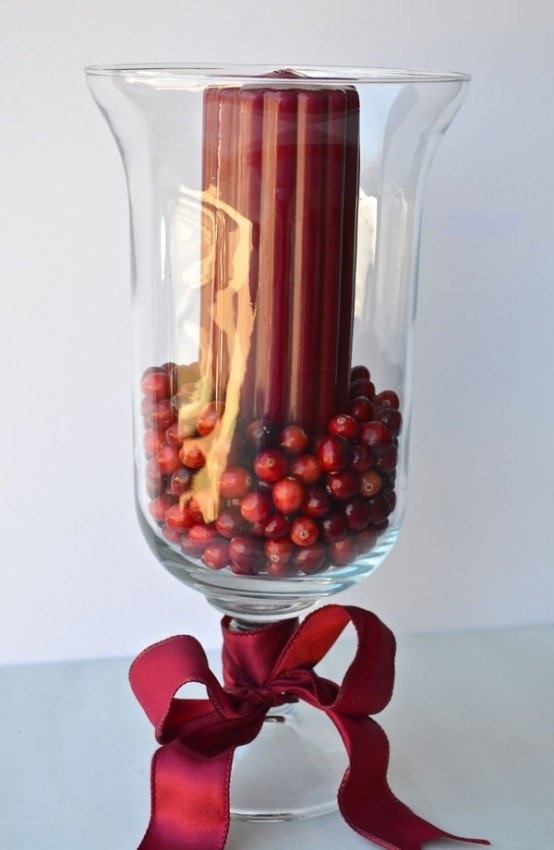a tall glass with cranberries and a burgundy candle plus a red bow is a beautiful and elegant Christmas decoration to rock