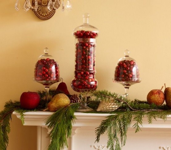 a tall jar and cloches filled with cranberries are amazing Christmas decor for a mantel, add evergreens and candles around and voila