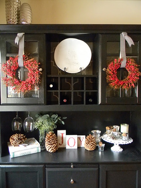 vine wreaths with cranberries, large pinecones and greenery are a great and cool combo to style a buffet, they will add a natural feel and plenty of color