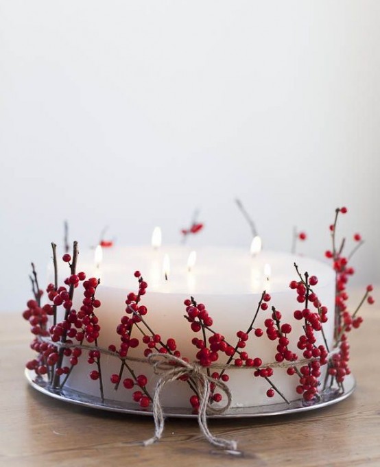 a silver tray with a large candle wrapped with holly berries and twine is a fantastic Christmas centerpiece or decoration