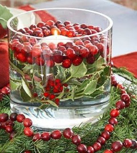 a large glass with water, greenery and cranberries plus a floating candle is a lovely holiday decoration or a centerpiece you can make last minute
