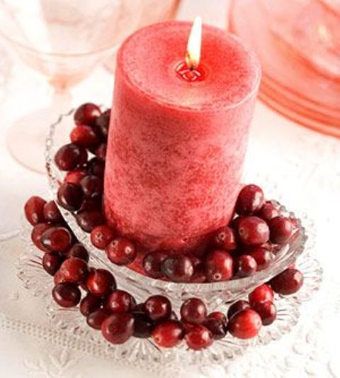 a Christmas centerpiece of a crystal bowl with cranberries and a coral candle on top is a gorgeous idea to realize last minute