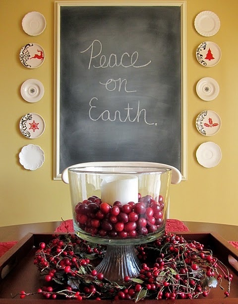 a large glass with cranberries and a single pillar candle plus a matchign wreath under it is a cool idea for a rustic or natural space