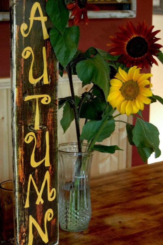 a shabby chic autumn sign and sunflowers next to it for a relaxed rustic fall look