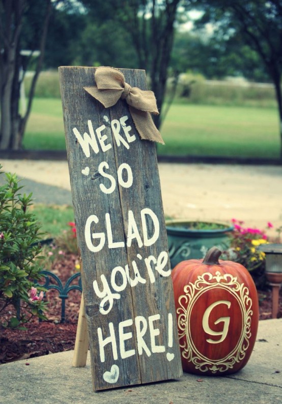 a reclaimed wood sign with a burlap bow and a painted pumpkin for a rustic fall touch to the space