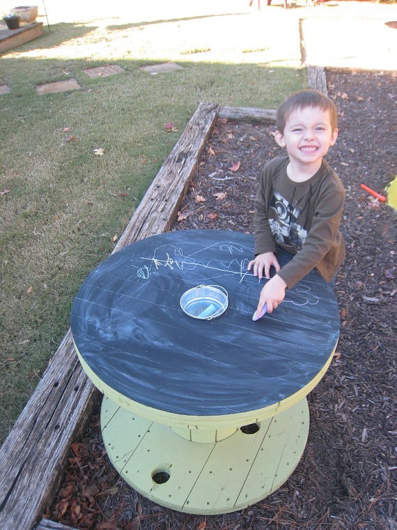 a wooden chalkboard table and colorful chalk is great for creativity and art outdoors