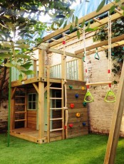 a green lawn, a wooden house, ladders, a climbing wall, various sporty touches for kids having fun here