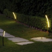 small curved modern outdoor lamps like these ones can line up a wlakway or a path or give light to some far part of your garden without being too bright
