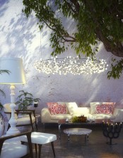 a classic white table lamp shaped as a traditional one with a lampshade is a gorgeous idea to give an outdoor space a feeling of an indoor one