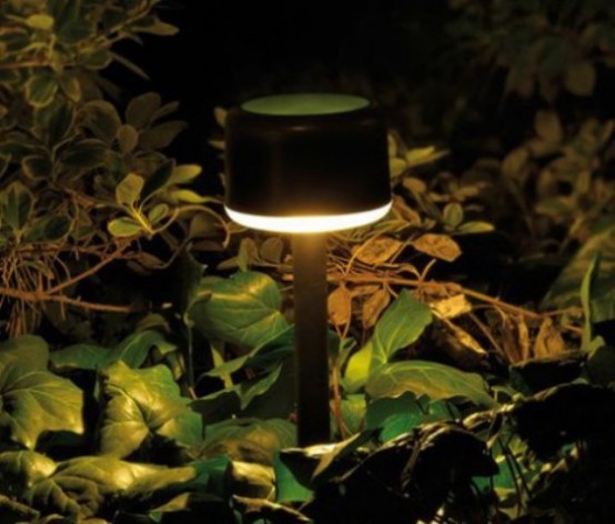 a small outdoor lamp of a catchy shape illuminates only yhe ground, great for lighting up walkways and paths