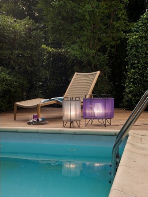 a wooden lounger and small floor lamps with a neutral and a purple semi sheer lampshade are amazing for outdoors
