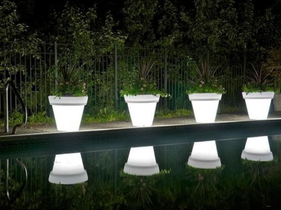 illuminated planters with greenery are amazing to line up a walkway or even a pool and they won't take much space as they are double-duty pieces