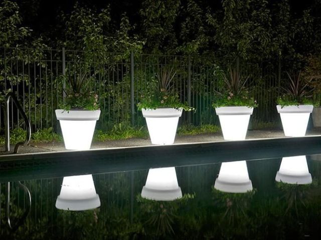 illuminated planters with greenery are amazing to line up a walkway or even a pool and they won't take much space as they are double duty pieces