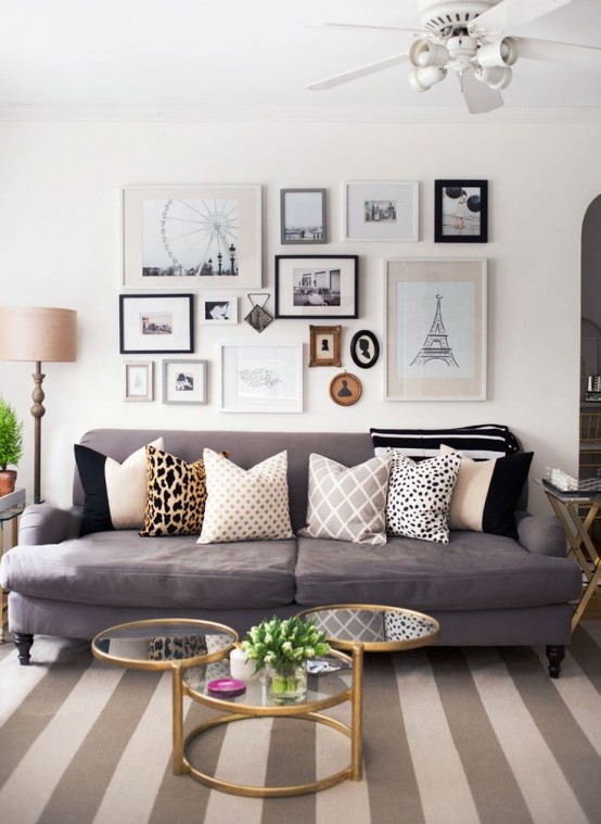 a neutral living room with a taupe sofa, a pretty contrasting gallery wall and a grey and tan strip rug to make the space cooler