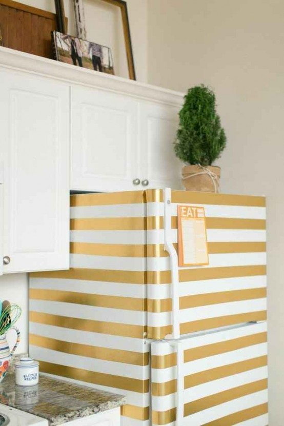a fridge renovated with adhesive paper and turned into a creative and bold piece with its gold and white stripes will accent your kitchen