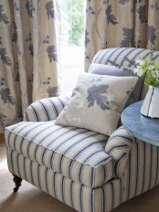 a classic vintage navy and white striped chair with some pillows welcomes to sit here and looks very nice