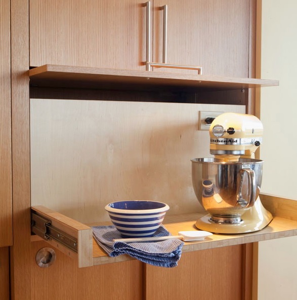 a cabinet with a retracting shelf, a mixer and a bowl helps to hide pieces that you need only from time to time
