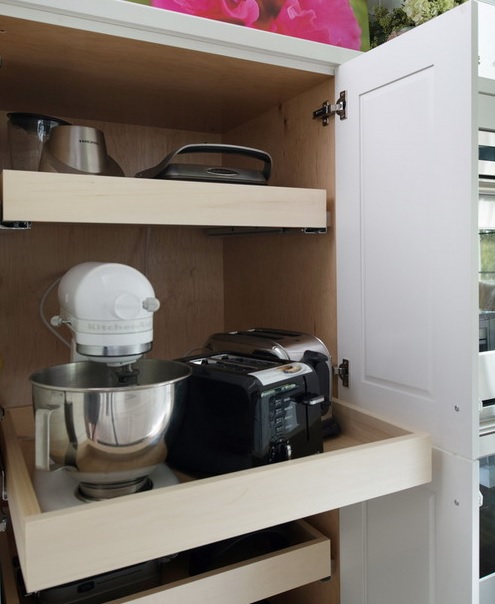 a cabinet with several retracting shelves that hold various applainces and is amazing for every kitchen to keep the clutter away