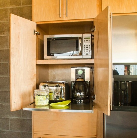 a light stained plywood cabient with several appliances and a retractable shelf is a very comfy idea to make your kitchen look neat