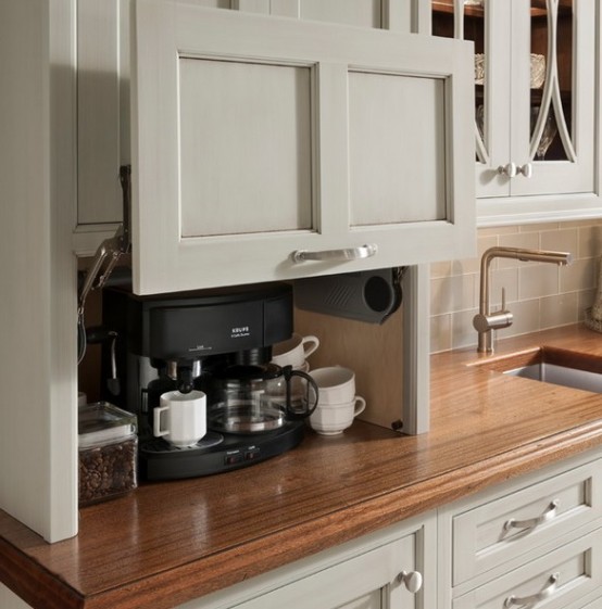 a storage cabinet with a retractable door and a mini coffee station inside, with coffee and a coffee machine