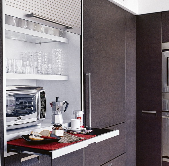 a large cabinet with a shutter cover and usual and retractable shelves with appliances and a microwave allows serving breakfast here