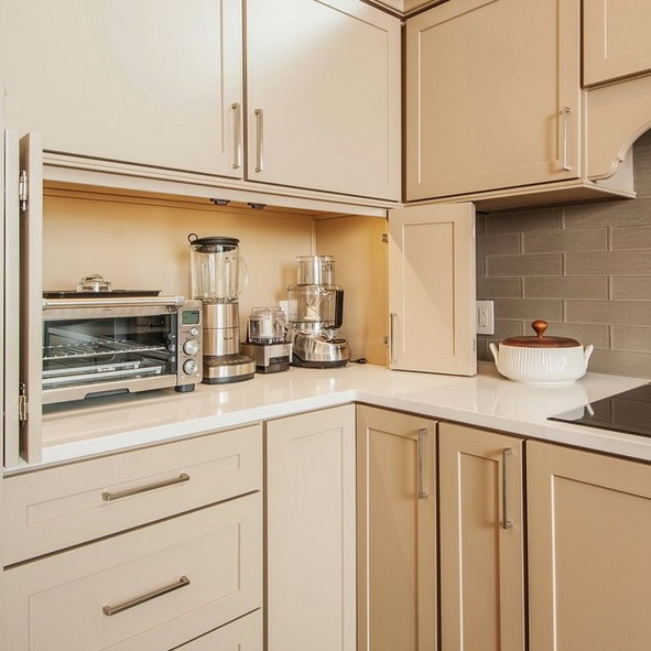 a small neutral cabinet with folding doors hides several kitchen appliances and gives the kitchen a neater look